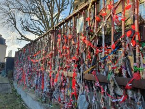 Streams of red umbrellas with the names of sex workers lost to violence hung on the gates of Crossbones Graveyard on a bright, sunny winter day