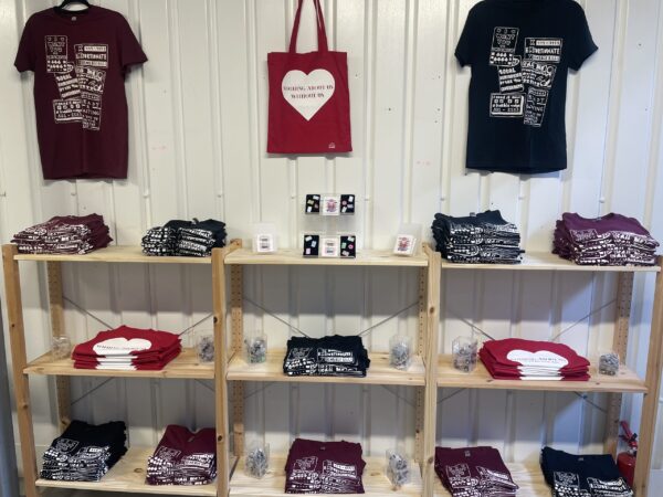 A display of t-shirts, tote bags and badges at the Vagina Museum
